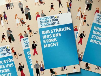 Mehrere gleichaussehende Flyer der Partnerschaft für Demokratie Landkreis Sankt Wendel.