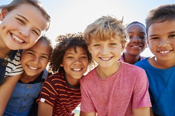 Eine Gruppe von Kindern, die lächelnd den Betrachter anblickt.