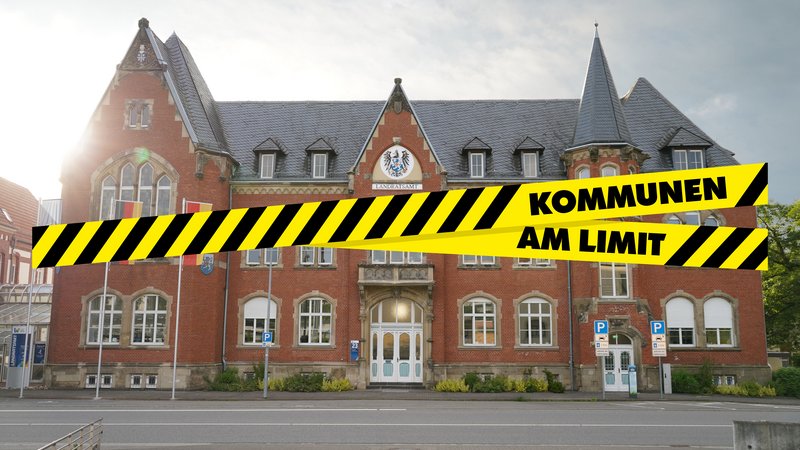 Landratsamt in St. Wendel mit einer Grafik eines Absperrbands mit der Aufschrift Kommunen am Limit