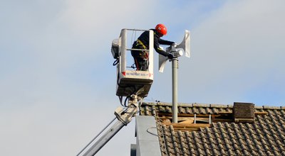 Arbeiten an einer Sirene auf einem Dach